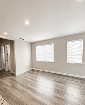 Chico apartment for rent - A room with light wood flooring and two windows with white blinds.