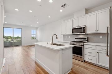 Martinez townhouse for rent - A modern kitchen with white cabinets and stainless steel appliances.