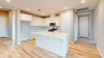 Chico apartment for rent - A kitchen with a white island and wooden floors.