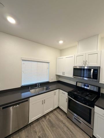 Chico apartment for rent - A kitchen with white cabinets and black countertops.