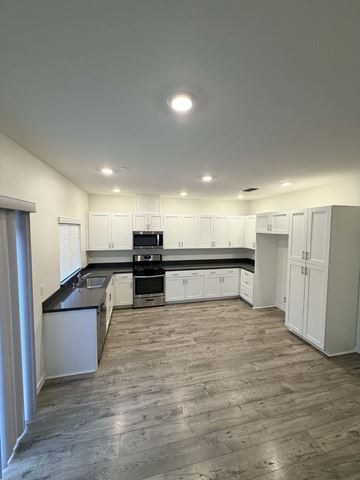 Chico apartment for rent - A kitchen with white cabinets and a black countertop.