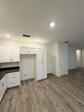 Chico apartment for rent - A kitchen with white cabinets and a wooden floor.