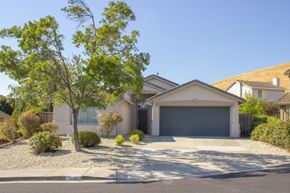 Bay Point apartment for rent - A house with a grey garage door and a tree in front.