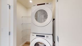 Okotoks apartment for rent - A white dryer is stacked on top of a white washing machine.