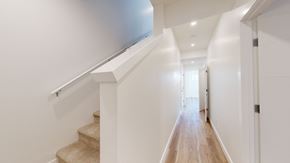 Okotoks apartment for rent - A long hallway with a staircase on the left side.