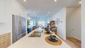 Okotoks apartment for rent - A modern kitchen with a stainless steel refrigerator and a wooden countertop.
