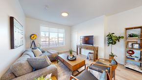 Okotoks apartment for rent - A living room with a grey couch, a wooden coffee table, and a TV on a stand.