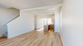 Okotoks apartment for rent - A spacious room with wooden flooring and white walls.