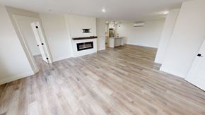 Fredericton apartment for rent - A spacious room with wooden flooring and a fireplace.