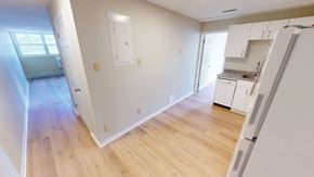 Fredericton apartment for rent - A kitchen area with white cabinets and a refrigerator.