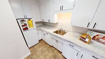Fredericton apartment for rent - A kitchen with white cabinets and a tiled floor.