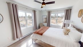 Fredericton apartment for rent - A bedroom with a large bed and a ceiling fan.