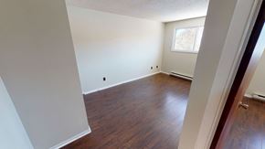 Fredericton apartment for rent - A room with wooden floors and white walls.