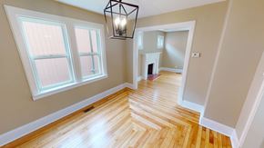 Fredericton apartment for rent - A room with wooden floors and a chandelier hanging from the ceiling.