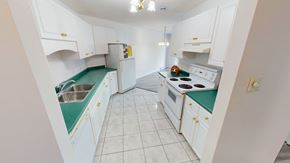 Fredericton apartment for rent - A kitchen with white cabinets and green countertops.