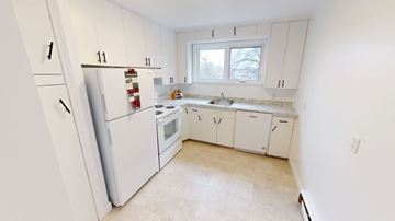 Fredericton apartment for rent - A kitchen with white appliances and cabinets.