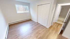 Fredericton apartment for rent - A room with a wooden floor and a white door.