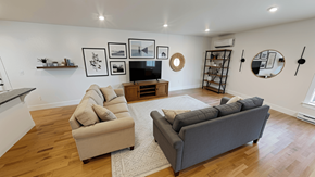 Fredericton apartment for rent - A living room with a grey couch and a beige armchair.