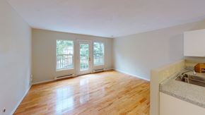 Fredericton apartment for rent - A room with wooden floors and a kitchen area with a sink.
