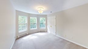 Fredericton apartment for rent - A room with a white door and a window with a view of trees.