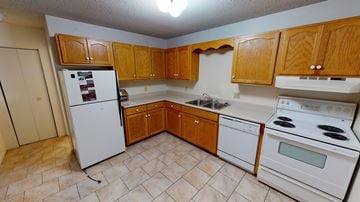 Fredericton apartment for rent - A kitchen with wooden cabinets and white appliances.