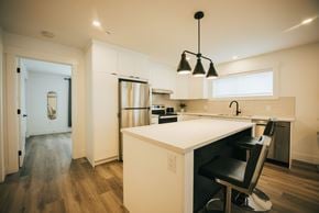 Fredericton apartment for rent - A kitchen with a white counter and a black chair.