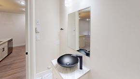 Fredericton apartment for rent - A bathroom with a black bowl sink and a mirror.
