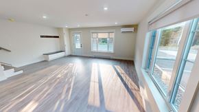 Fredericton apartment for rent - A spacious room with wooden floors and a staircase on the left side.