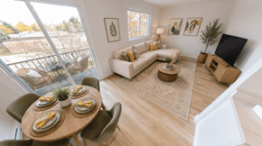 Fredericton apartment for rent - A living room with a couch, a coffee table, a television, and a dining table with chairs.