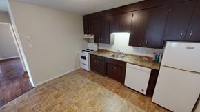 Fredericton apartment for rent - A kitchen with brown cabinets and white appliances.