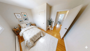 Fredericton apartment for rent - A bedroom with a bed, nightstand, and pictures on the wall.