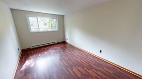 Fredericton apartment for rent - A room with a wooden floor and a window letting in sunlight.