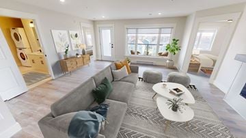 Fredericton apartment for rent - A living room with a grey sofa and a white coffee table.