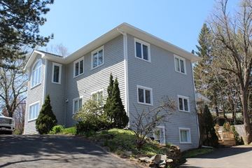 Fredericton apartment for rent - A grey house with a white trim and a grey roof.