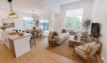 Fredericton apartment for rent - A modern living room with a kitchen area in the background.