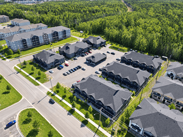 Fredericton apartment for rent - A bird's eye view of a residential area with houses and cars.