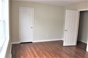 Fredericton apartment for rent - A room with two white doors and wooden floors.