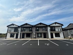 Fredericton apartment for rent - A large building with a parking lot in front of it.