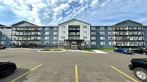Fredericton apartment for rent - A parking lot in front of a large apartment building.