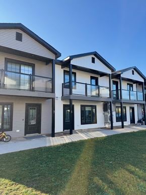 Fredericton apartment for rent - A row of modern houses with balconies and glass doors.