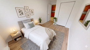 Fredericton apartment for rent - A bedroom with a bed, nightstand, and framed pictures on the wall.