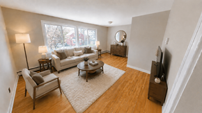 Fredericton apartment for rent - A living room with a white couch, a wooden coffee table, and a large window.