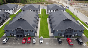 Fredericton apartment for rent - A parking lot with cars in front of a building.