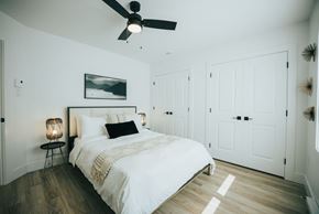 Fredericton apartment for rent - A bedroom with a large bed and a ceiling fan.