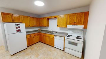 Fredericton apartment for rent - A kitchen with wooden cabinets and white appliances.