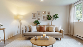 Fredericton apartment for rent - A living room with a couch, a table, and a lamp.