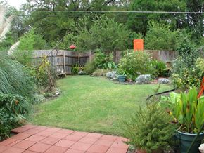 Dallas apartment for rent - A backyard with a green lawn and a brick walkway.