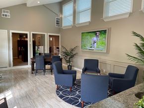 Dallas apartment for rent - A living room with a large screen and blue chairs.