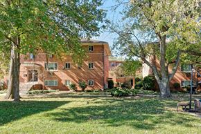 Alexandria apartment for rent - A large red brick building with a tree in front of it.