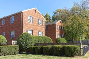 Alexandria apartment for rent - A red brick building with a black fence in front.